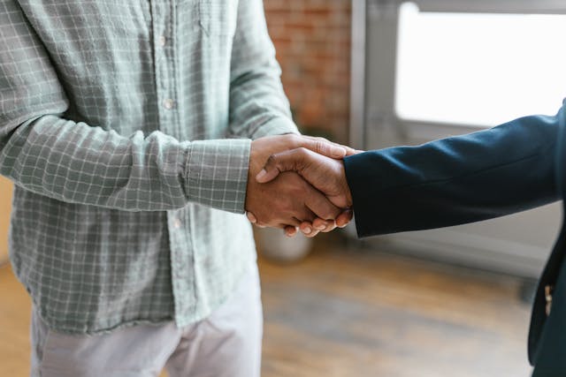 Two people shaking hands in a professional setting.