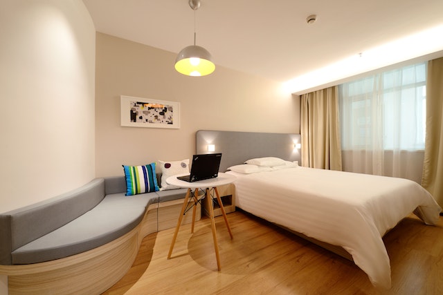 A modern bedroom with a built-in wall sofa and bed.