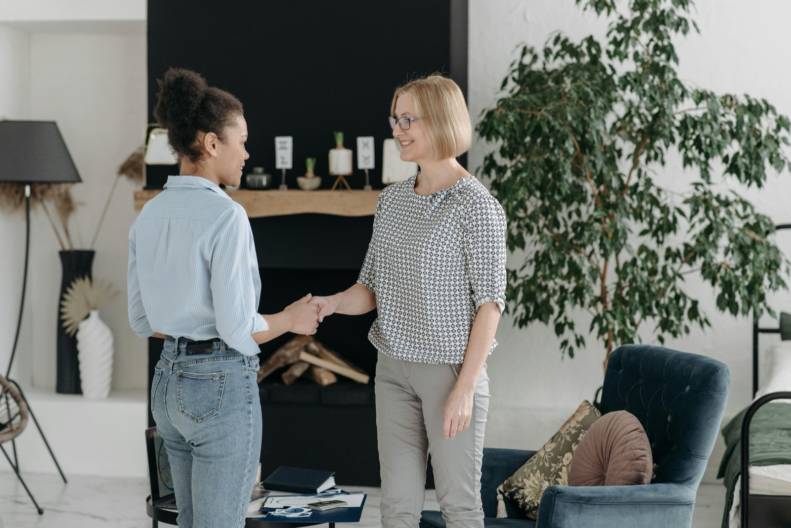 A landlord and tenant shaking hands in a modern living room.