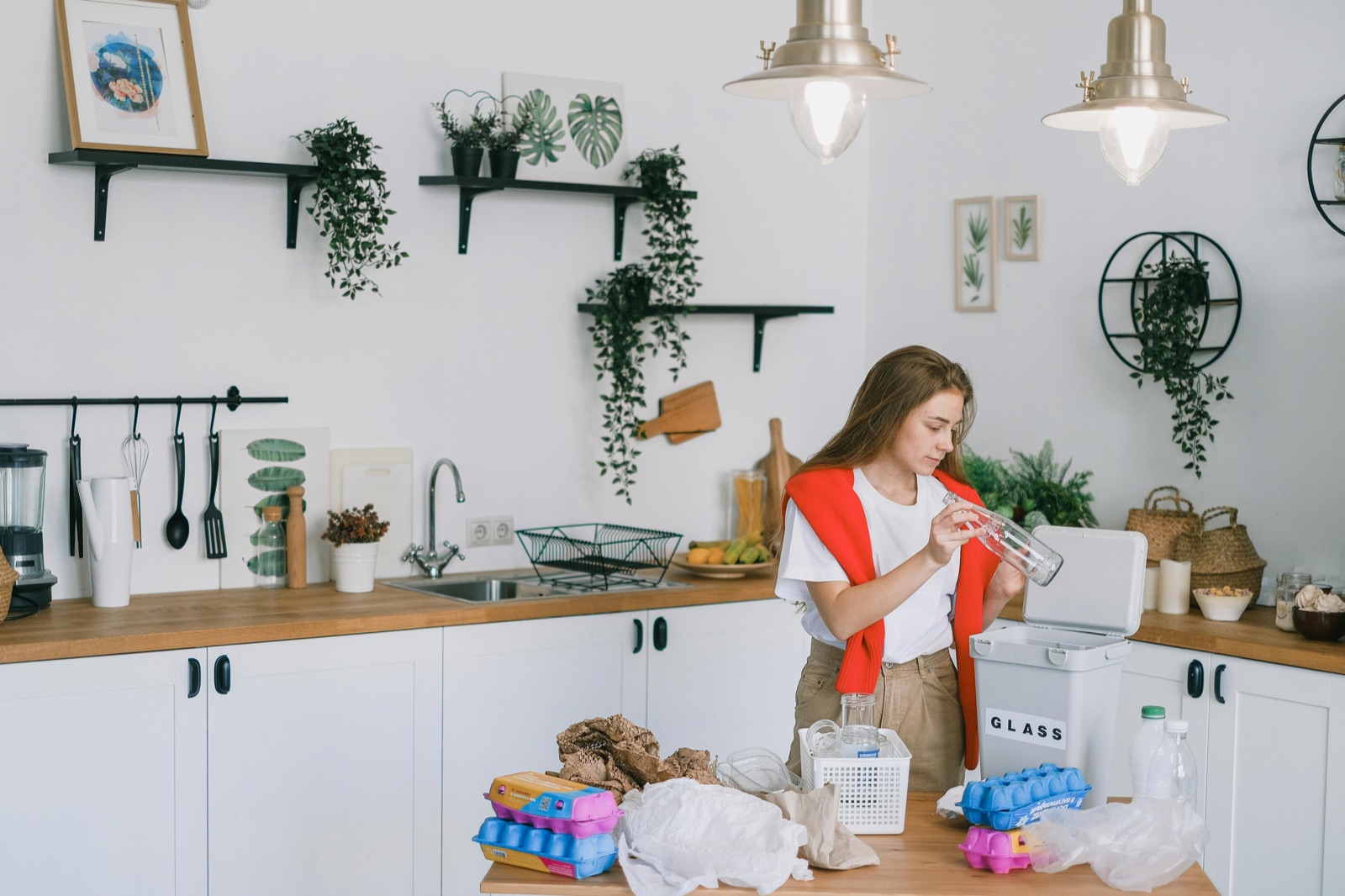 A tenant sorting recycling in a clean, modern kitchen.
