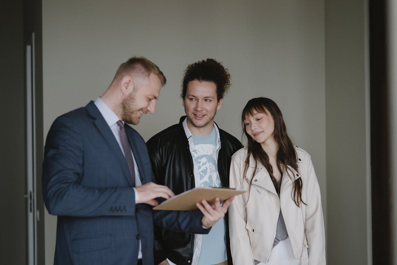 A property manager handing keys to a new tenant in a bright rental home.