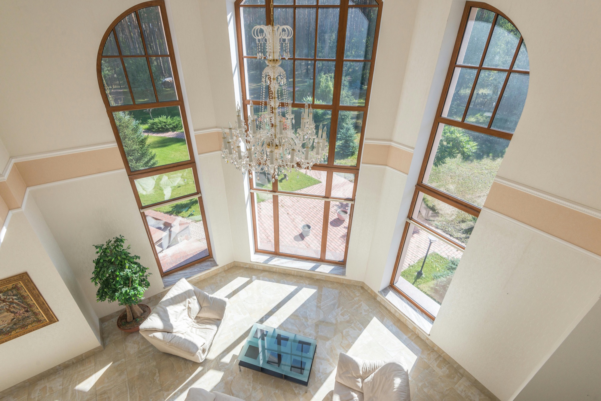 Modern luxury condominium living room with floor-to-ceiling windows and an elegant chandelier