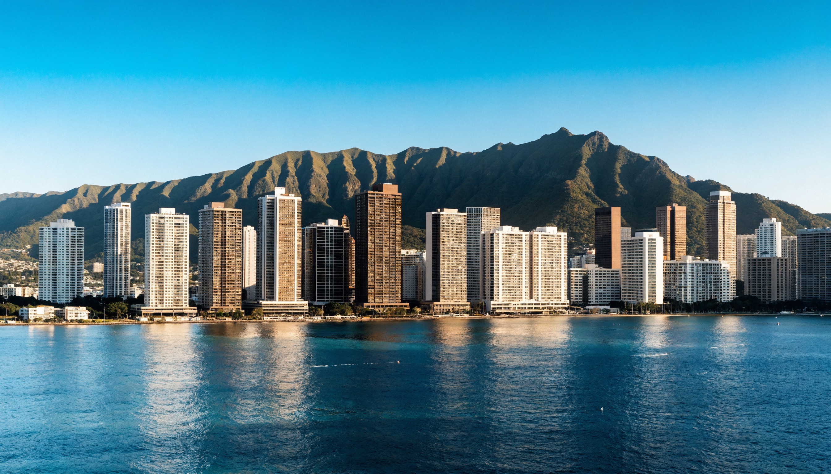 The Honolulu skyline of residential condominium towers with Diamond Head behind and the Pacific in the foreground.